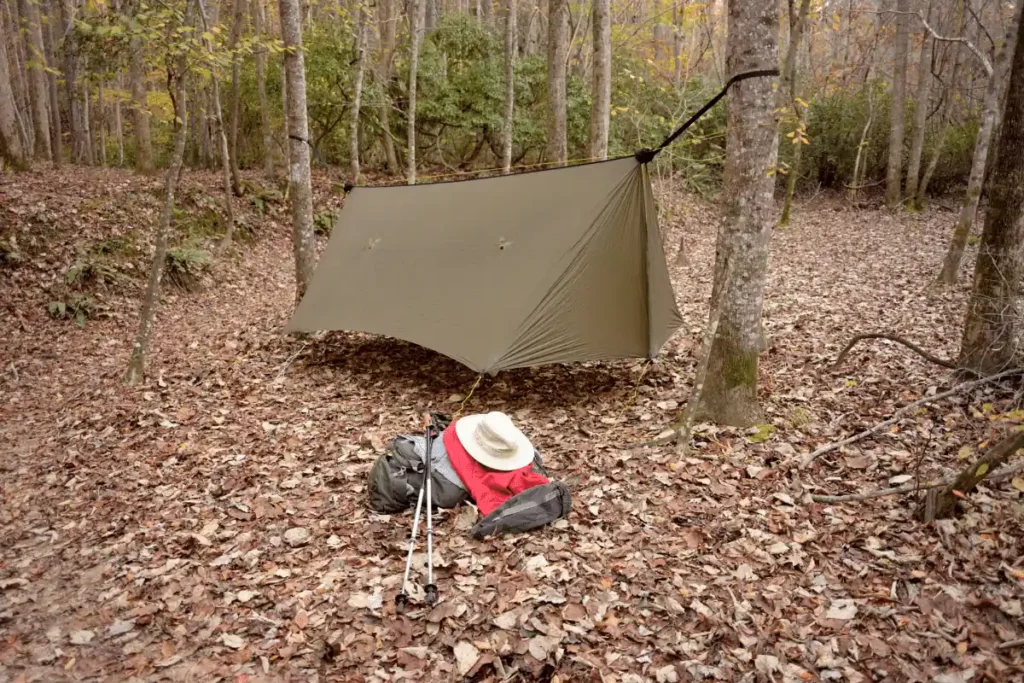 Hammock tarp with close doors on the trail with gear outside getting packed to leave