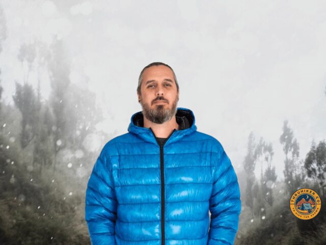 man in a azure blue Zpacks goose down jacket in the forest with snow