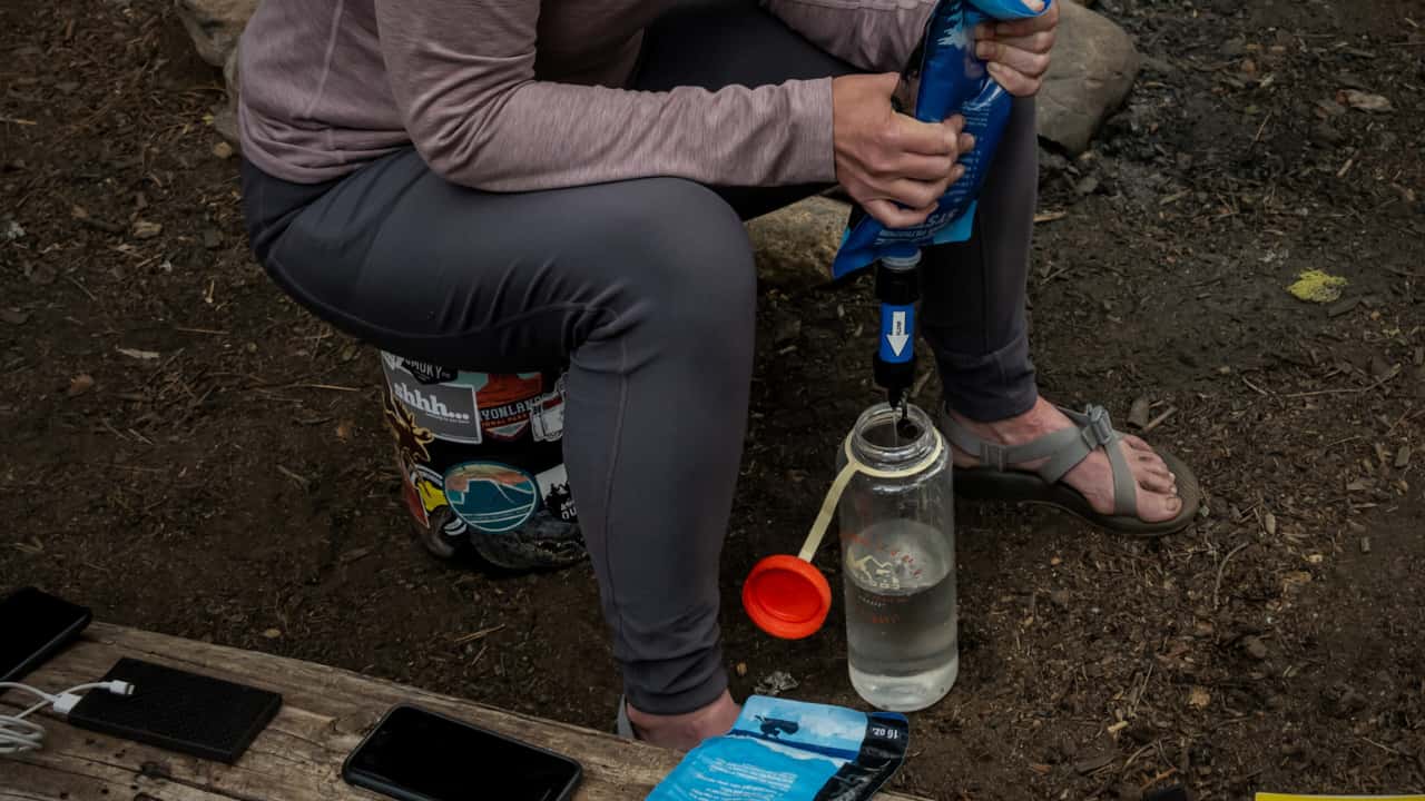 Hiker sitting on a bear canister